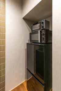 a microwave oven sitting on top of a shelf in a room at Choya Chawanzaka Machiya House in Kyoto