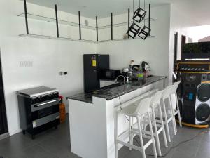 a kitchen with a counter and some stools in it at Villa Tobias San Juan Batangas in Batangas City