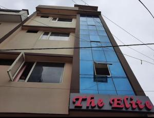 ein hohes Gebäude mit einem Schild davor in der Unterkunft Hotel The Elite, Katra in Katra