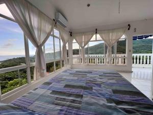 - une chambre avec un grand lit et de grandes fenêtres dans l'établissement Bella Luna Ocean View & Mountain, à El Zonte