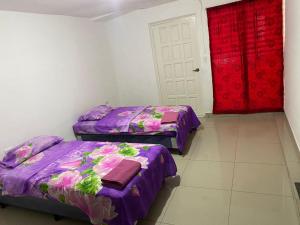 Habitación con 2 camas y puerta roja en La Mezcla Perfecta Hostal en Managua