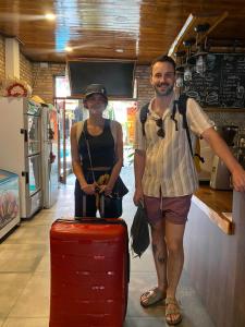 a man and a woman standing with a red suitcase at Ambedo Hotel Phu Quoc in Phu Quoc +75 photos