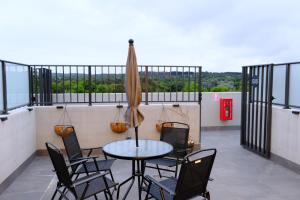 einen Tisch und Stühle auf einem Balkon mit Sonnenschirm in der Unterkunft Japanese Penthouse Retreat 1B1B 2 Parking 5-min tram-to-CBD Brekky Wifi Netflix in Canberra