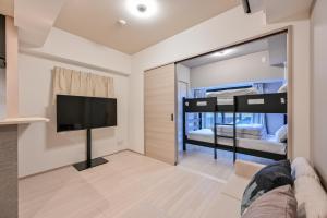 a bedroom with bunk beds and a flat screen tv at MP Hotel Hakata in Fukuoka