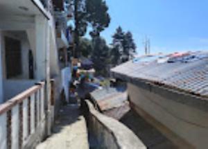 a building with a fence next to a house at Hotel H. K. Legacy Nainital in Nainital