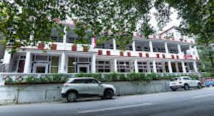 a white car parked in front of a large building at Hotel H. K. Legacy Nainital in Nainital