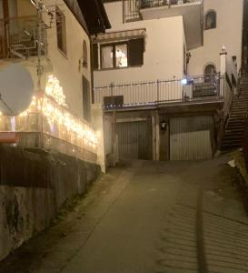 un callejón vacío con luces en el lateral de un edificio en Chez Papi - A 5 min da piste da Sci e Stazione CIR VDA AO 0013, en Aosta