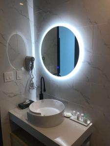 a bathroom with a sink with a round mirror at Aurora Villa in Fairbanks