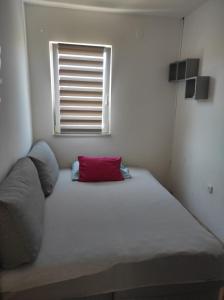 un grande letto in una stanza con finestra di Apartment Dani - with large terrace a Supetar (San Pietro di Brazza)
