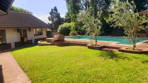 a yard with a swimming pool and a house at Secret guest house in Pietermaritzburg