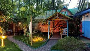 una casa con un jardín delante de ella en Moalboal Bamboo House / Rooms, en Moalboal