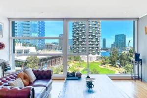 a living room with a couch and a large window at Luxury 4B Docklands Penthouse water city views in Melbourne