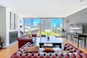 a living room with couches and a large window at Luxury 4B Docklands Penthouse water city views in Melbourne