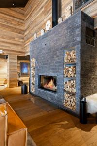 a fireplace in a living room with a stone wall at Penthouse Sammon in Levi