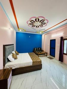 una camera con un grande letto e una parete blu di Goswami Guest House a Faizābād