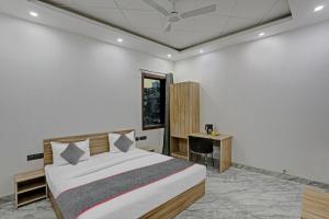 Un dormitorio con una cama grande y un escritorio. en Super Townhouse Xanthe - Boutique Hotel, en Noida