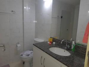 ein Badezimmer mit einem Waschbecken, einem WC und einem Spiegel in der Unterkunft Apartamento in Rio de Janeiro