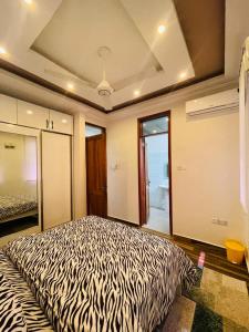 a bedroom with a zebra print bed in a room at ORANGE LIMITED TANZANIA in Dar es Salaam
