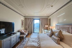a hotel room with a large bed and a television at Palazzo Versace - Blue Ocean Holiday Homes in Dubai