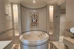 a large bathroom with a tub and a shower at Palazzo Versace - Blue Ocean Holiday Homes in Dubai