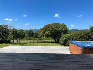 a patio with a blue bench and a park at Lake Holiday Home - Spa & Views in Mangakino