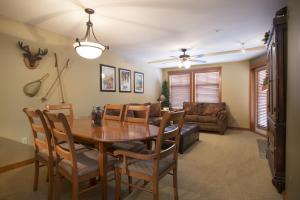 a dining room with a table and chairs and a couch at 1310 - One Bedroom Den Standard Eagle Springs West condo in Solitude