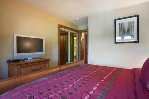 a bedroom with a bed and a flat screen tv at 2203 - One Bedroom Den Standard Eagle Springs East condo in Solitude