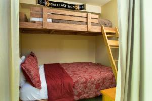 a bedroom with two bunk beds and a red bed at 2203 - One Bedroom Den Standard Eagle Springs East condo in Solitude