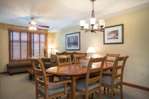 a dining room and living room with a table and chairs at 2203 - One Bedroom Den Standard Eagle Springs East condo in Solitude +5 photos
