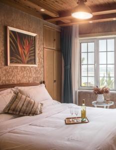 - une chambre avec un lit et un plateau de verres à vin dans l'établissement Qingdao Villa Inn, à Qingdao