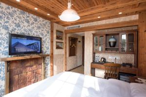 ein Schlafzimmer mit einem Bett und einem TV an der Wand in der Unterkunft Qingdao Villa Inn in Qingdao