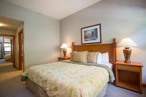a bedroom with a large bed and two lamps at 2312 - Two Bedroom Den Standard Eagle Springs East condo in Solitude