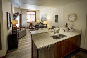 a kitchen with a sink and a living room at 3106- One Bedroom Den Deluxe Powderhorn Lodge Hotel Room in Solitude