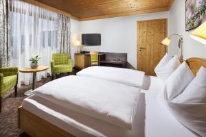 una camera d'albergo con due letti e una televisione di Hotel Metzgerwirt a Sankt Veit im Pongau
