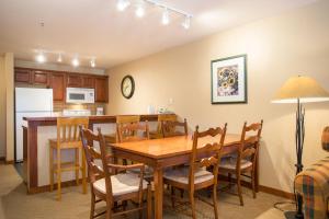 cocina y comedor con mesa de madera y sillas en 3313 - One Bedroom Den Standard Powderhorn Lodge condo, en Solitude