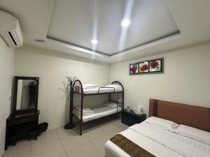 a bedroom with two bunk beds and a mirror at Grand Line Hotel Semporna in Semporna