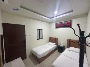 een kamer met twee bedden en een lamp erin bij Grand Line Hotel Semporna in Semporna