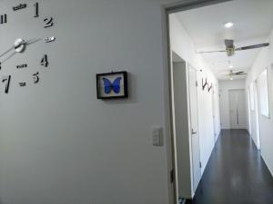 un pasillo con un reloj en una pared blanca en Pension Le Passage - Vacation STAY 11300v, en Tottori