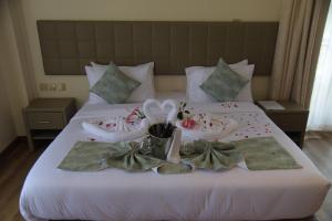 ein Bett mit Handtüchern und Hausschuhen darauf in der Unterkunft SpringWells Hotel ltd in Maua