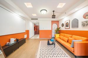 an office with an orange couch in a room at 一抹云栖世博店-公寓民宿 in Shanghai