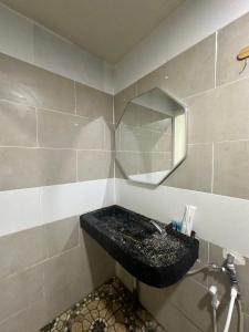 een badkamer met een wastafel en een spiegel bij Grand Line Hotel Semporna in Semporna