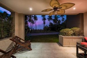 a patio with a ceiling fan and a view of the ocean at Klong Son Resortel in Ban Khlong Son