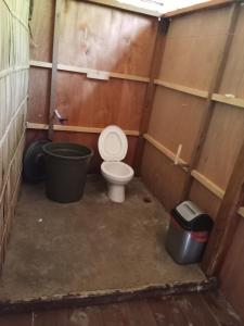 uma casa de banho com WC e duas latas de lixo em byuk Beya homestay em Kri