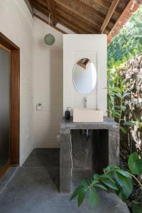 een badkamer met een wastafel en een spiegel bij Pool House Studios in Kuta Lombok