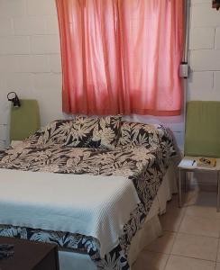 a bed sitting in a room with a window at La Casita de Marley in Villa Santa Cruz del Lago