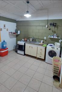 a kitchen with a stove and a washing machine at La Casita de Marley in Villa Santa Cruz del Lago