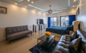 un salon avec un canapé et un lit dans l'établissement Jomtien Beachfront Stylish Studio , Stunning Seaview , Big Pool, à Jomtien Beach