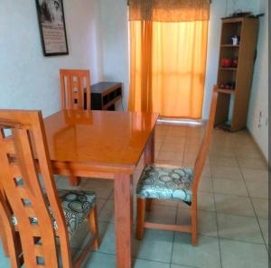 a dining room table with two chairs and a wooden table at Casa sola dos niveles in Chalco de Díaz Covarrubias