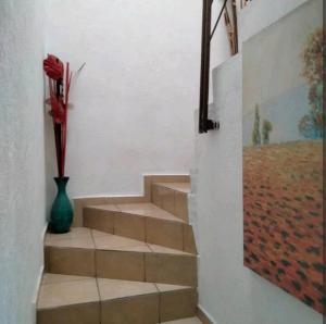 una escalera con un jarrón y un jarrón con una flor en Casa sola dos niveles, en Chalco de Díaz Covarrubias