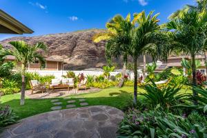 @Marbella Lane-Pōmaika'i LoveNest Ocean+MT View في Waianae: حديقة فيها نخيل وجبل في الخلفية